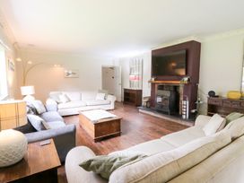 A living room with a fireplace and sofa at Tynewydd Fields in Cross Inn