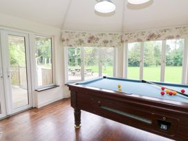 A game room with a pool table near large windows at Tynewydd Fields in Cross Inn