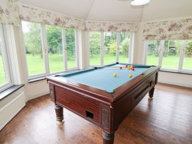 A game room with a pool table and windows at Tynewydd Fields in Cross Inn