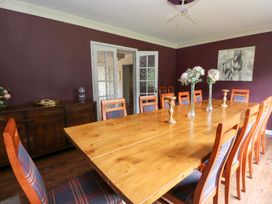 A dining room with a large table and wooden chairs at Tynewydd Fields in Cross Inn