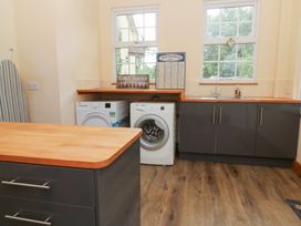 A laundry room with washing machines and storage cabinets at Tynewydd Fields in Cross Inn