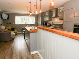 A kitchen with bar counter and seating at Tynewydd Fields in Cross Inn