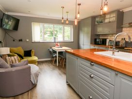 A kitchen with a table and chairs plus a sofa at Tynewydd Fields in Cross Inn