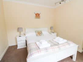 A bedroom with a bed and bedside tables at Tynewydd Fields in Cross Inn