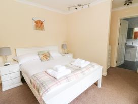 A bedroom with a bed and nightstands at Tynewydd Fields in Cross Inn