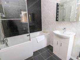 A bathroom with a bathtub and washbasin at Tynewydd Fields in Cross Inn