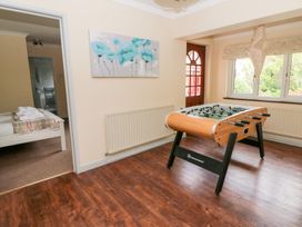 A game room with a foosball table and a view into a bedroom at Tynewydd Fields, Cross Inn
