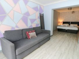 A living room with a sofa and entrance to a bedroom at Tynewydd Fields in Cross Inn