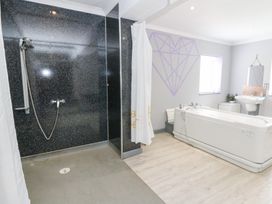 A bathroom with a shower and bathtub at Tynewydd Fields in Cross Inn