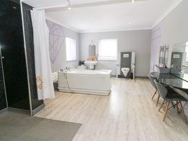 A bathroom with a bathtub, shower, toilet and sink at Tynewydd Fields in Cross Inn