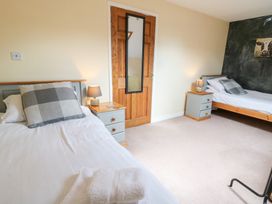 A bedroom with two single beds and bedside tables at Tynewydd Fields in Cross Inn