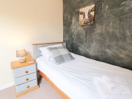 A bedroom with a single bed and nightstand at Tynewydd Fields in Cross Inn