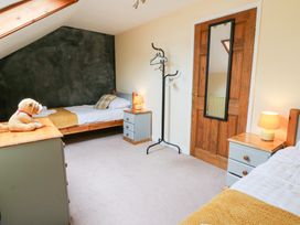 A bedroom with two beds and a coat stand at Tynewydd Fields in Cross Inn