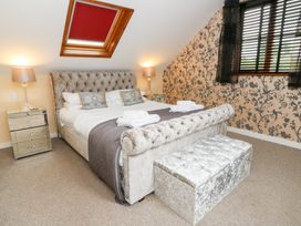 A bedroom with a bed and nightstands at Tynewydd Fields in Cross Inn