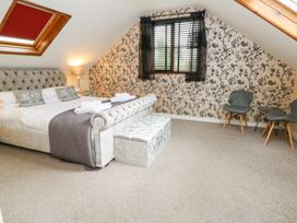 A bedroom with a large bed and seating area at Tynewydd Fields in Cross Inn