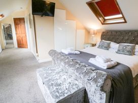 A bedroom with a bed and television at Tynewydd Fields in Cross Inn