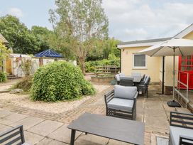 A garden area with seating and a table at Tynewydd Fields in Cross Inn