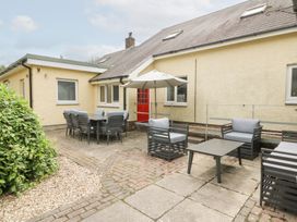 An outdoor seating area with a table and umbrella at Tynewydd Fields in Cross Inn