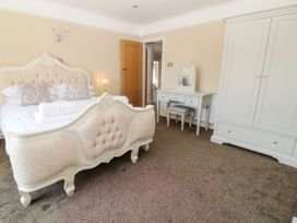 A bedroom with a double bed wardrobe dressing table and stool at Harbour Lights in Torquay