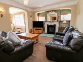 A living room with leather sofas a wooden coffee table a television and a fireplace at Harbour Lights in Torquay