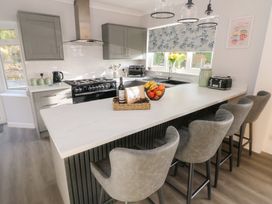 A kitchen with a bar counter and stools at Westwinds in Tenby
