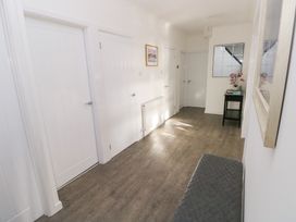 A hallway with doors and a mirror at Westwinds in Tenby