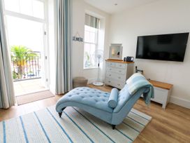 A living room with a chaise lounge and television at 4 The Beaches in Weymouth
