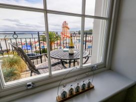 A window view showing a table with a bottle and beach outside at 4 The Beaches Weymouth