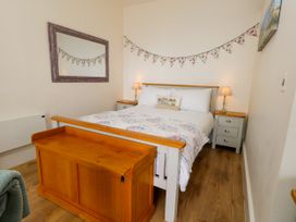 A bedroom with a bed, bedside tables, and a mirror at 4 The Beaches in Weymouth