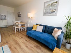 A living room with a sofa and dining table at 4 The Beaches in Weymouth
