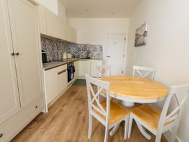 A kitchen with a table and chairs at 4 The Beaches in Weymouth