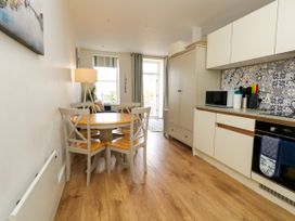 A kitchen with a dining area and appliances at 4 The Beaches in Weymouth