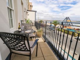 A balcony with a table and chairs overlooking a street at 4 The Beaches Weymouth