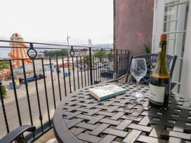 A balcony with a bottle of wine and a glass overlooking a view at 4 The Beaches Weymouth
