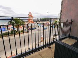 A balcony view overlooking a road and beach at 4 The Beaches in Weymouth