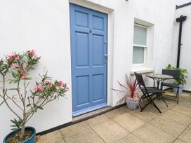 An outdoor area with a blue door and seating at 4 The Beaches in Weymouth