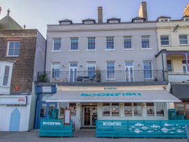 A restaurant building with a balcony and sign at 4 The Beaches in Weymouth