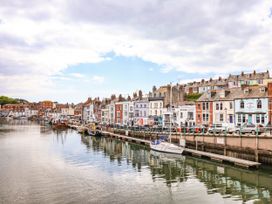 A waterfront view with buildings and boats at 4 The Beaches Weymouth