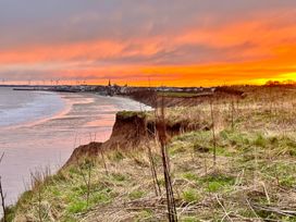 A sunset view over the beach and cliffs at Bobbies Retreat, 20 High Street, Bridlington