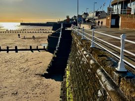 A beach view with people walking along the sand at Bobbies' Retreat, 20 High Street, Bridlington