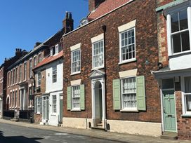 A brick building with green shutters and front door in Bridlington