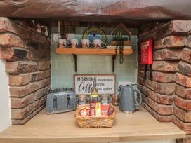 A kitchen area with a kettle, toaster, mugs, and a basket at Bobbies' Retreat, 20 High Street, Bridlington