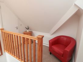 A landing with a red armchair and wooden railing at Bobbies Retreat, 20 High Street in Bridlington