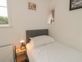 A bedroom with a bed and lamp at Bobbies Retreat, 20 High Street, Bridlington