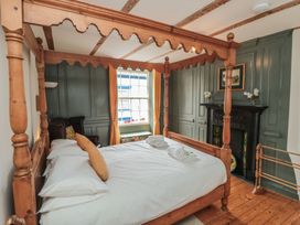 A bedroom with a four-poster bed and wooden furniture at Bobbies' Retreat, 20 High Street, Bridlington