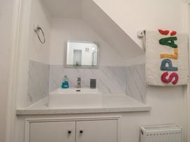 A bathroom with a sink and mirror at Bobbies' Retreat, 20 High Street, Bridlington