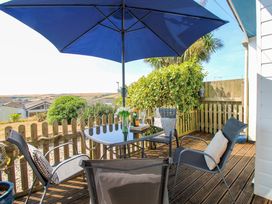 An outdoor seating area with table and chairs at Merlin in Malborough