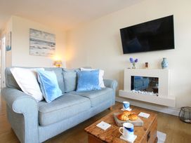 A living room with a sofa and television at Merlin in Malborough
