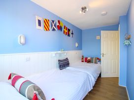 A bedroom with two beds and nautical flags at Merlin in Malborough