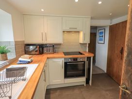 A kitchen with appliances and cabinets at Green Stile Cottage in Bowness-On-Windermere